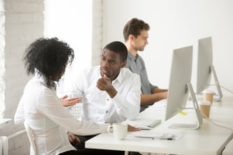 serious-african-american-colleagues-talking-discussing-project-together-workplace